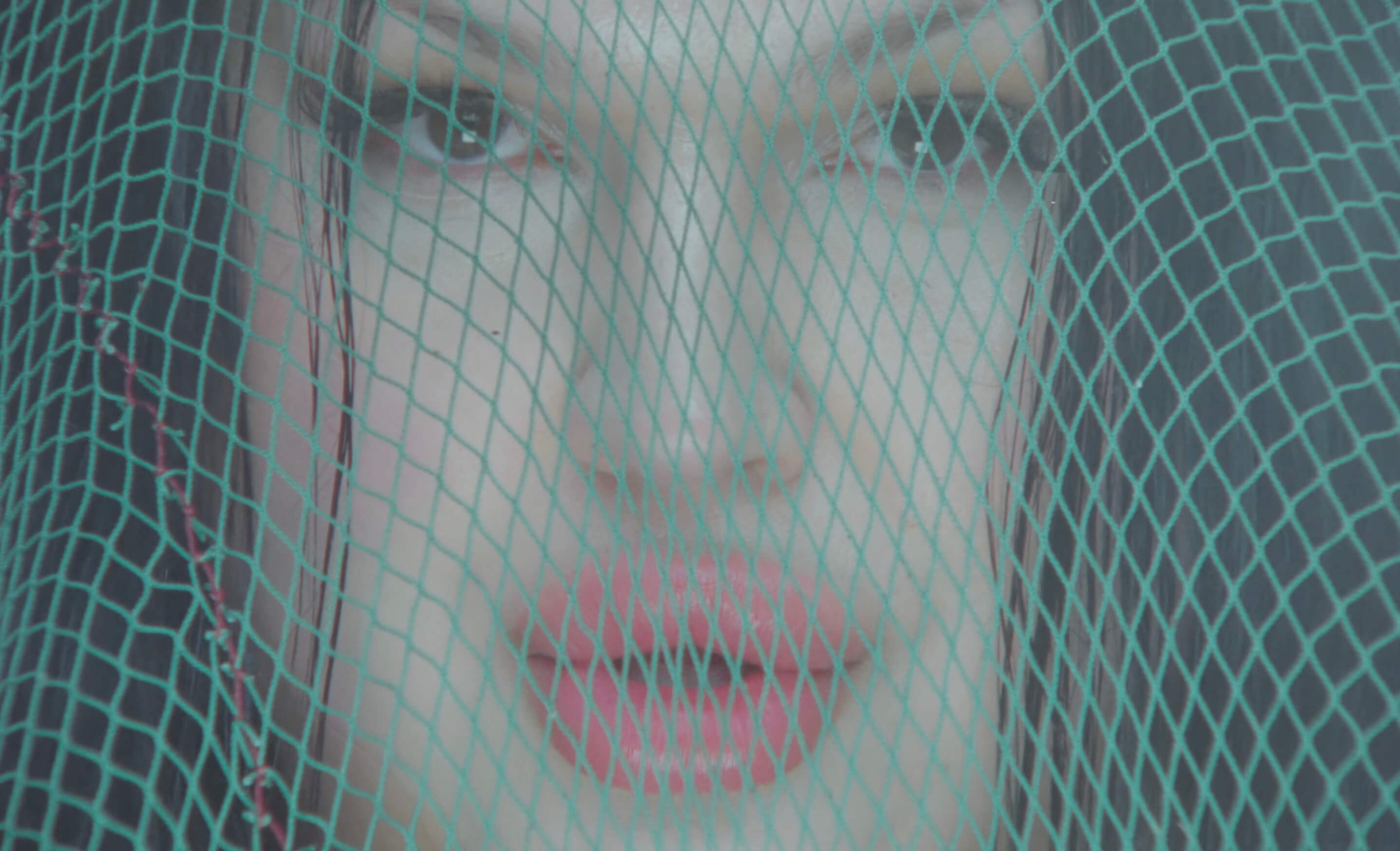 Extreme close-up обличчя Angel крізь бірюзову рибальську сітку